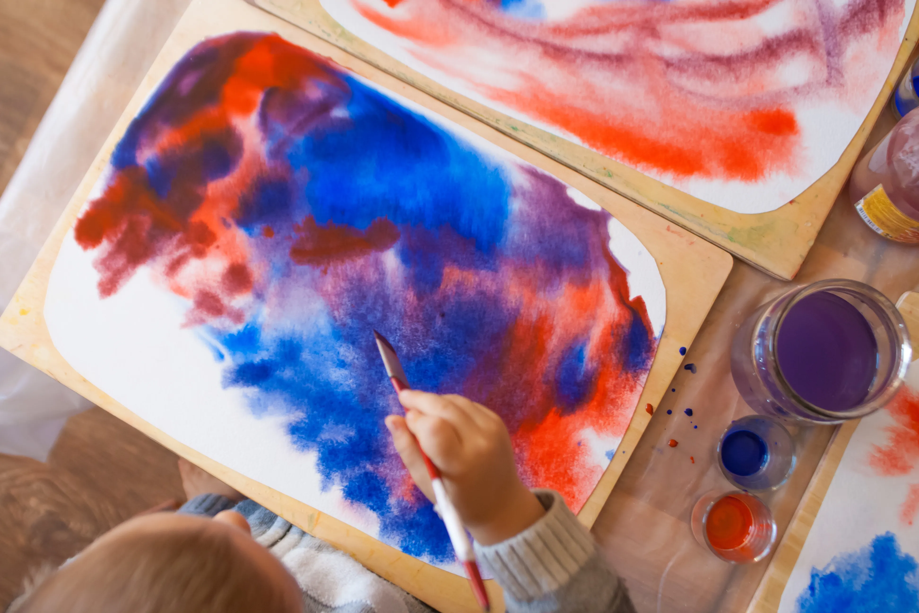 Aquarellbild eines Kindes — Wasserfarben in Blau und Rot