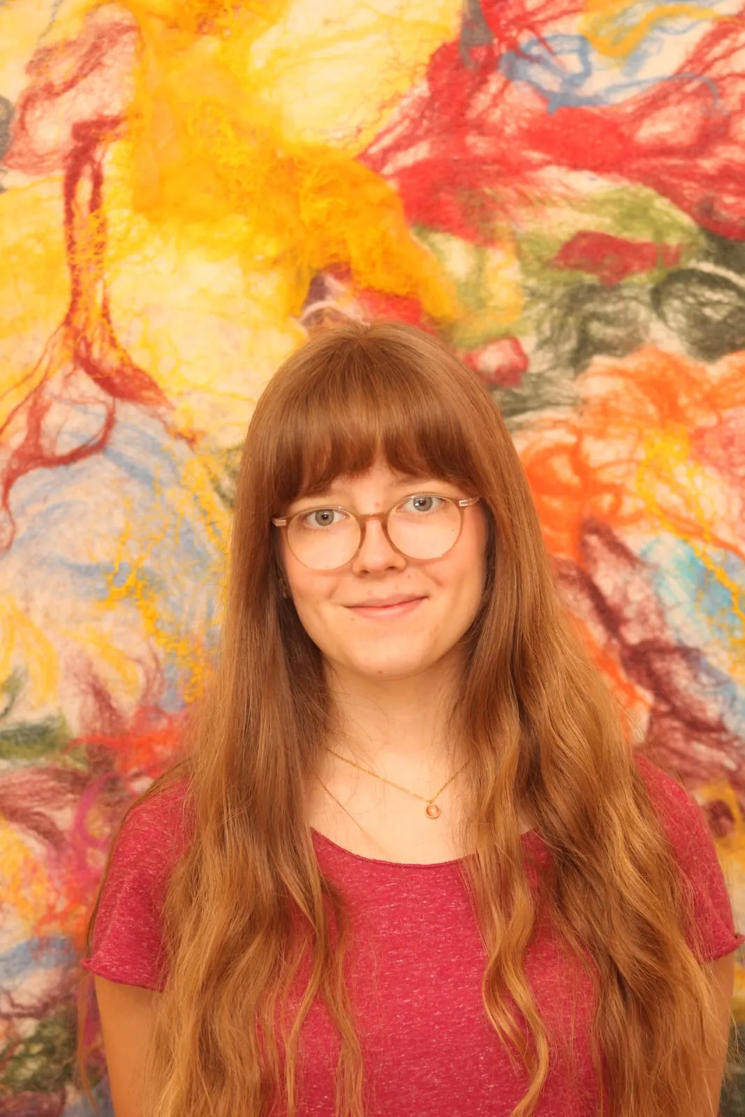 Mitglied unseres Kollegiums vor der Wachsmal-Wand der Schule