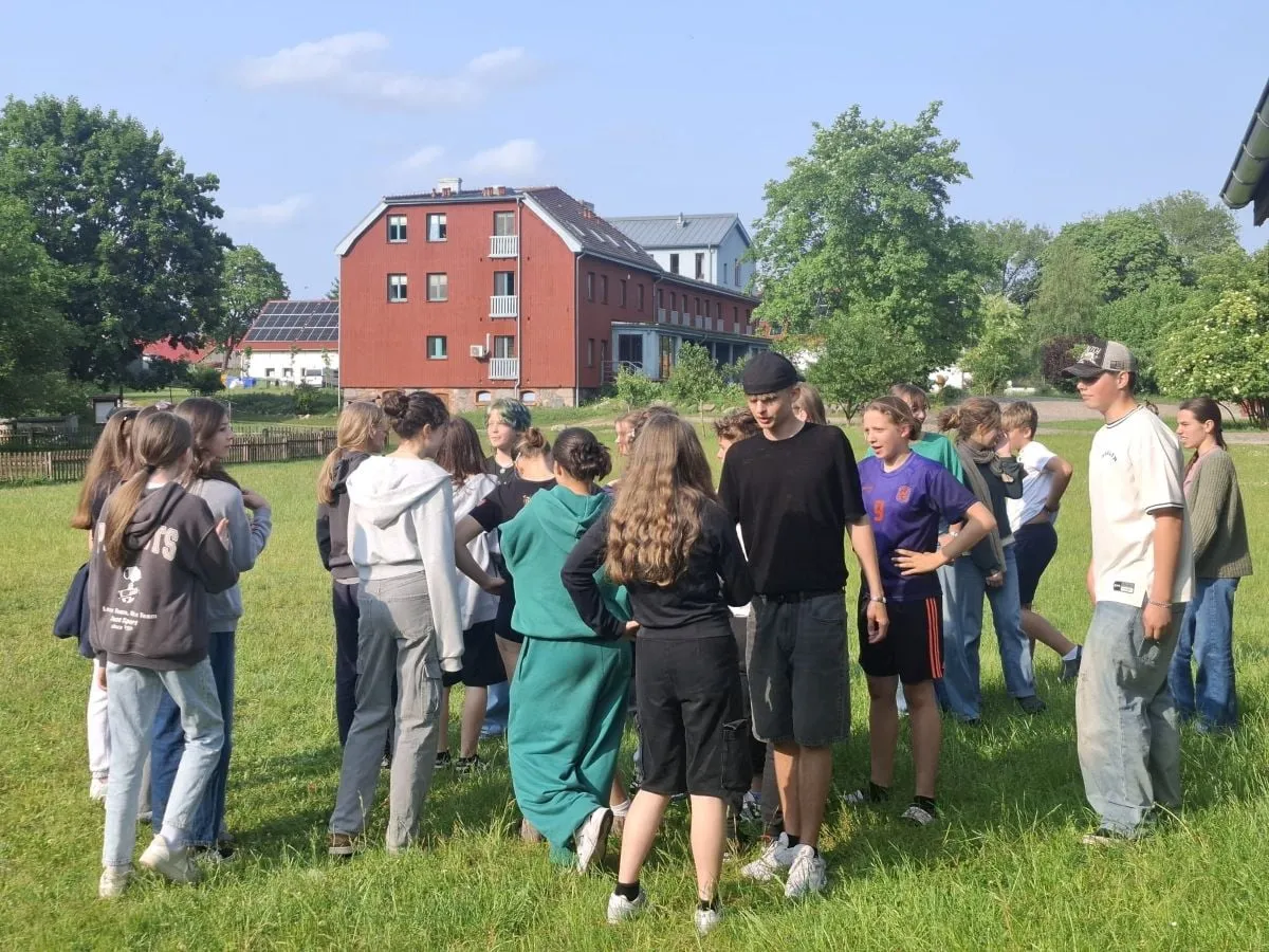 Schülerinnen und Schüler im Gespräch auf einer Wiese
