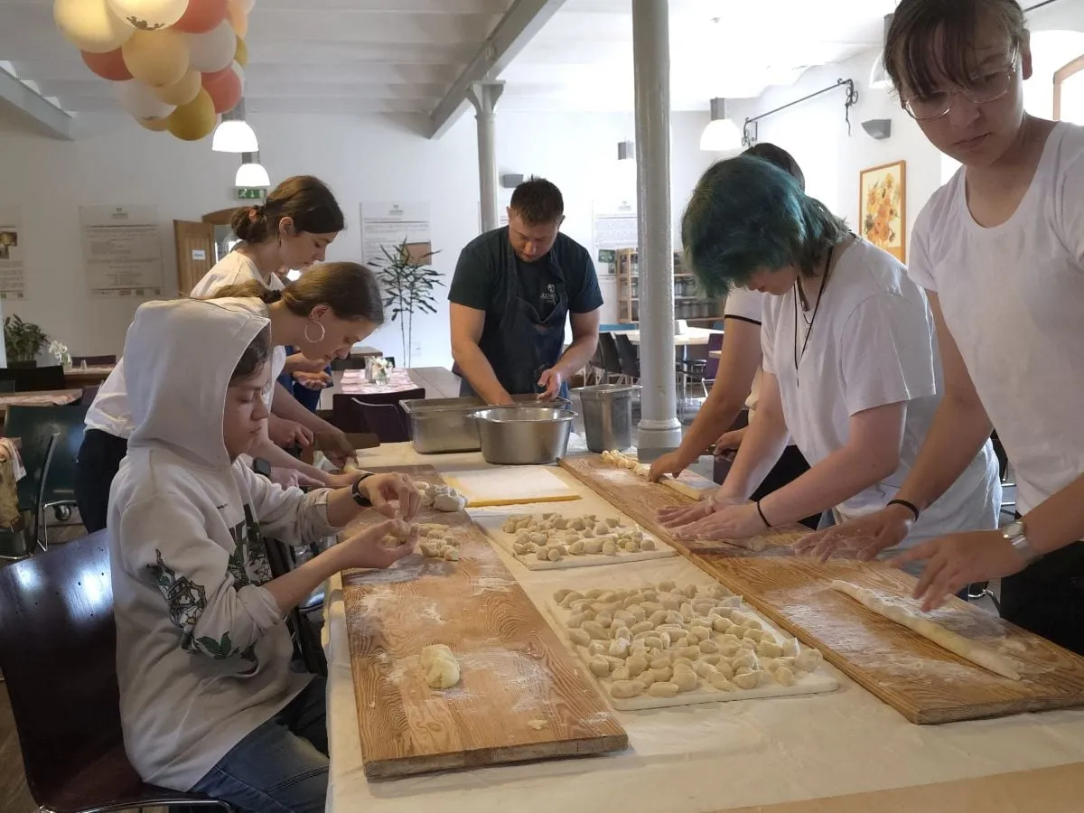 Jugendliche arbeiten gemeinsam an einem langen Tisch
